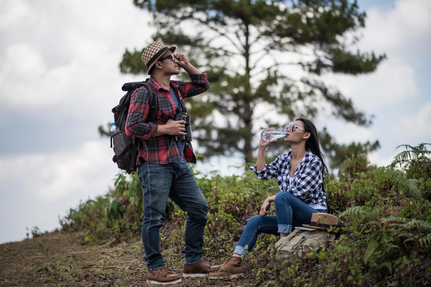 jeune couple regardant la carte lors d'une randonnée dans la forêt photo