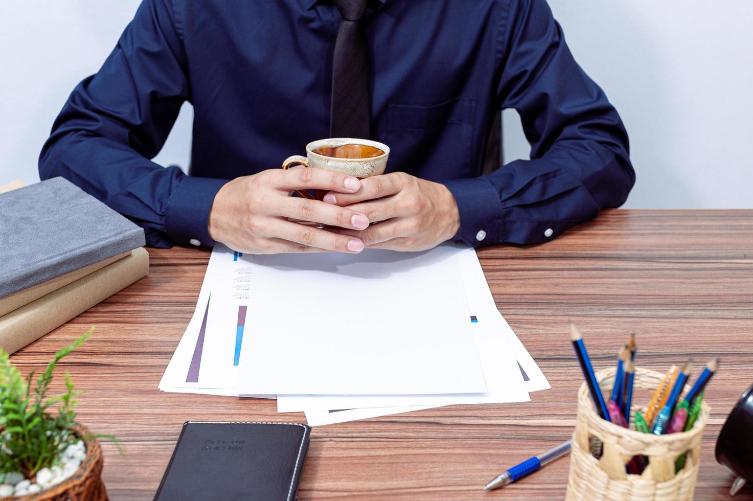 homme d & # 39; affaires tenant une tasse de café au bureau photo