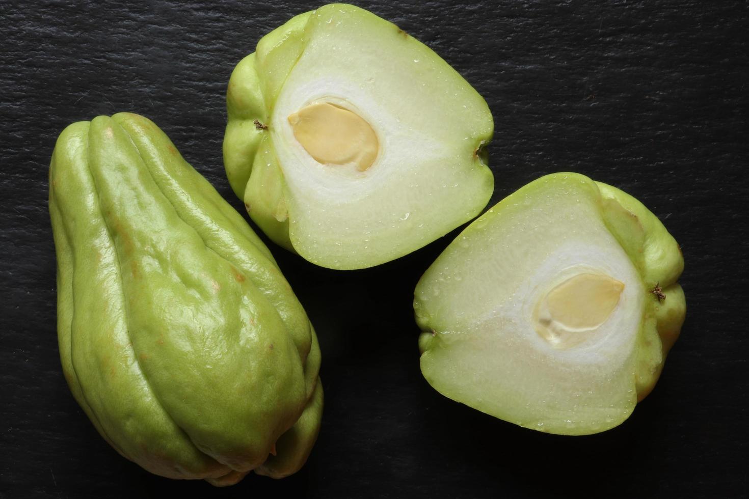 chayote en tranches sur fond noir photo