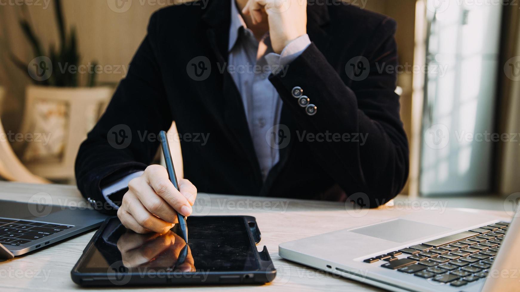 homme d'affaires mature utilisant une tablette numérique pour discuter d'informations avec un jeune collègue dans un salon d'affaires moderne photo