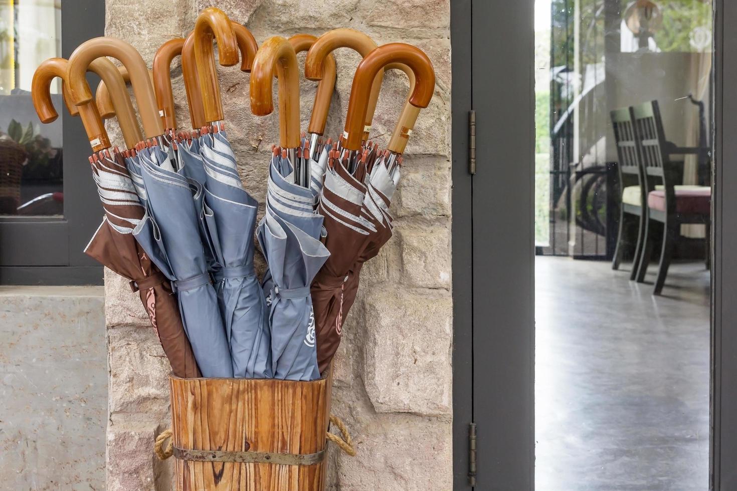 De nombreux parapluies pliés stockés dans un conteneur en bois à la maison photo