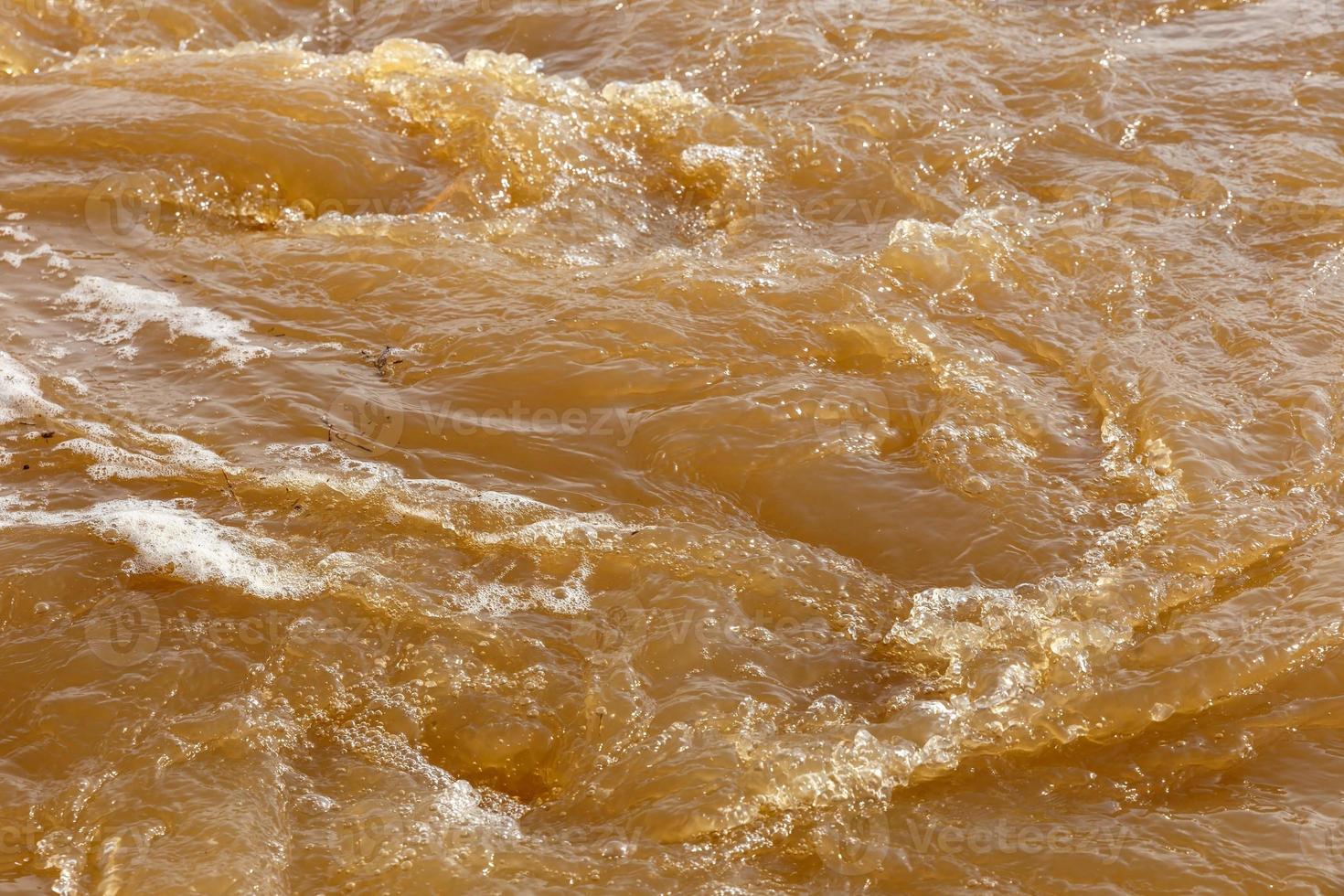 eau de rivière boueuse. eau boueuse sale avec bain à remous et gros plan de mousse blanche. photo