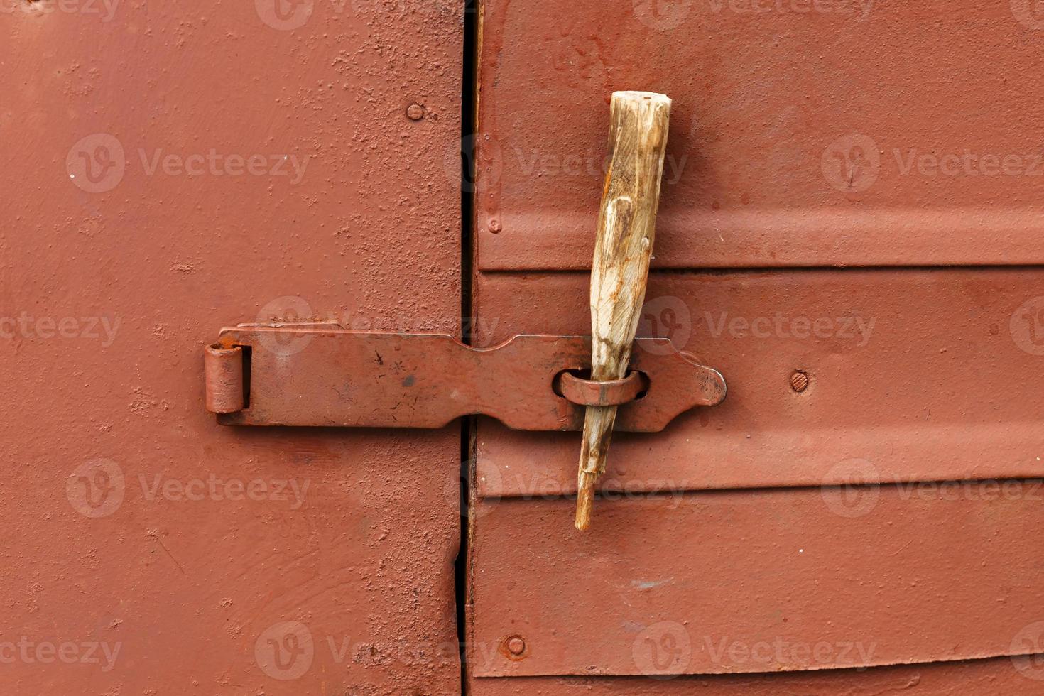 loquet sur la porte en fer. un bâton en bois est inséré à la place d'un  cadenas. 19031577 Photo de stock chez Vecteezy