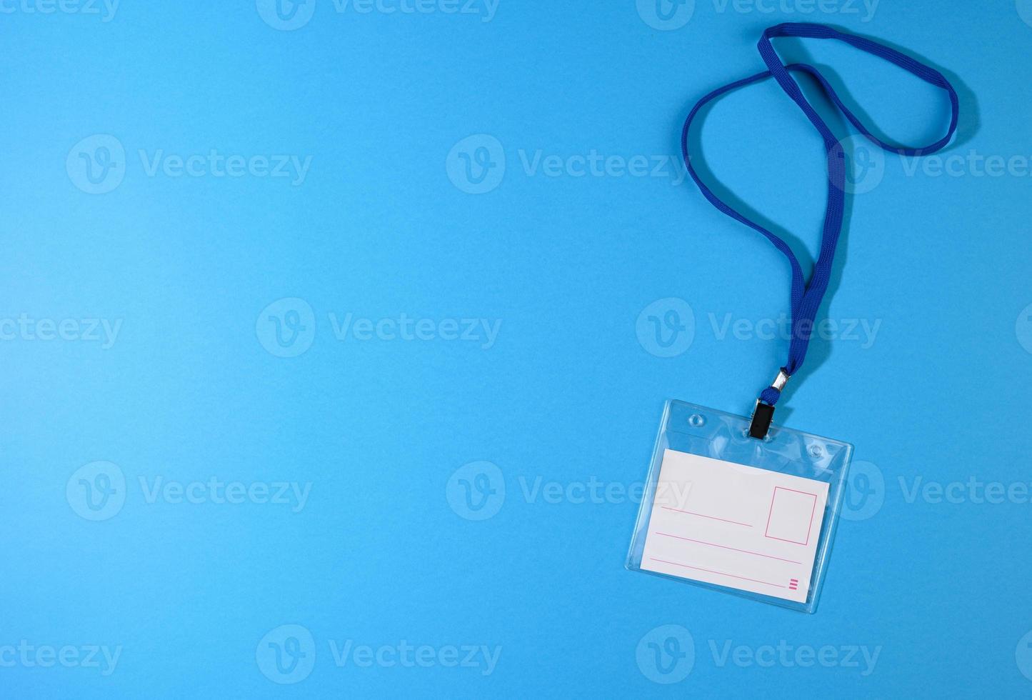 badge en plastique transparent sur un cordon bleu sur fond bleu photo