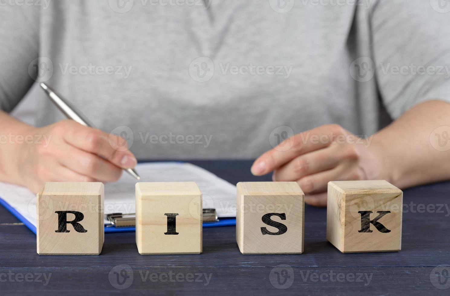 risque d'inscription sur des cubes en bois et une femme assise à la table. concept d'analyse de transaction commerciale photo