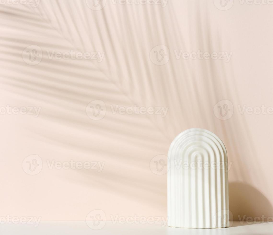 podium avec arche blanche pour présenter les cosmétiques, produits et autres marchandises. feuille de palmier d'ombre photo