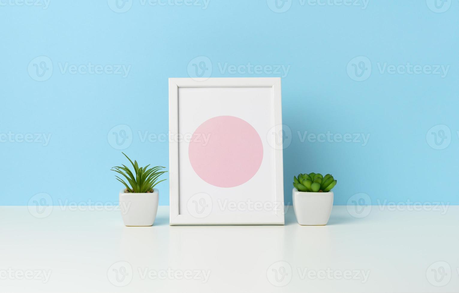 cadre photo en bois blanc vide et pots de fleurs avec des plantes sur tableau blanc