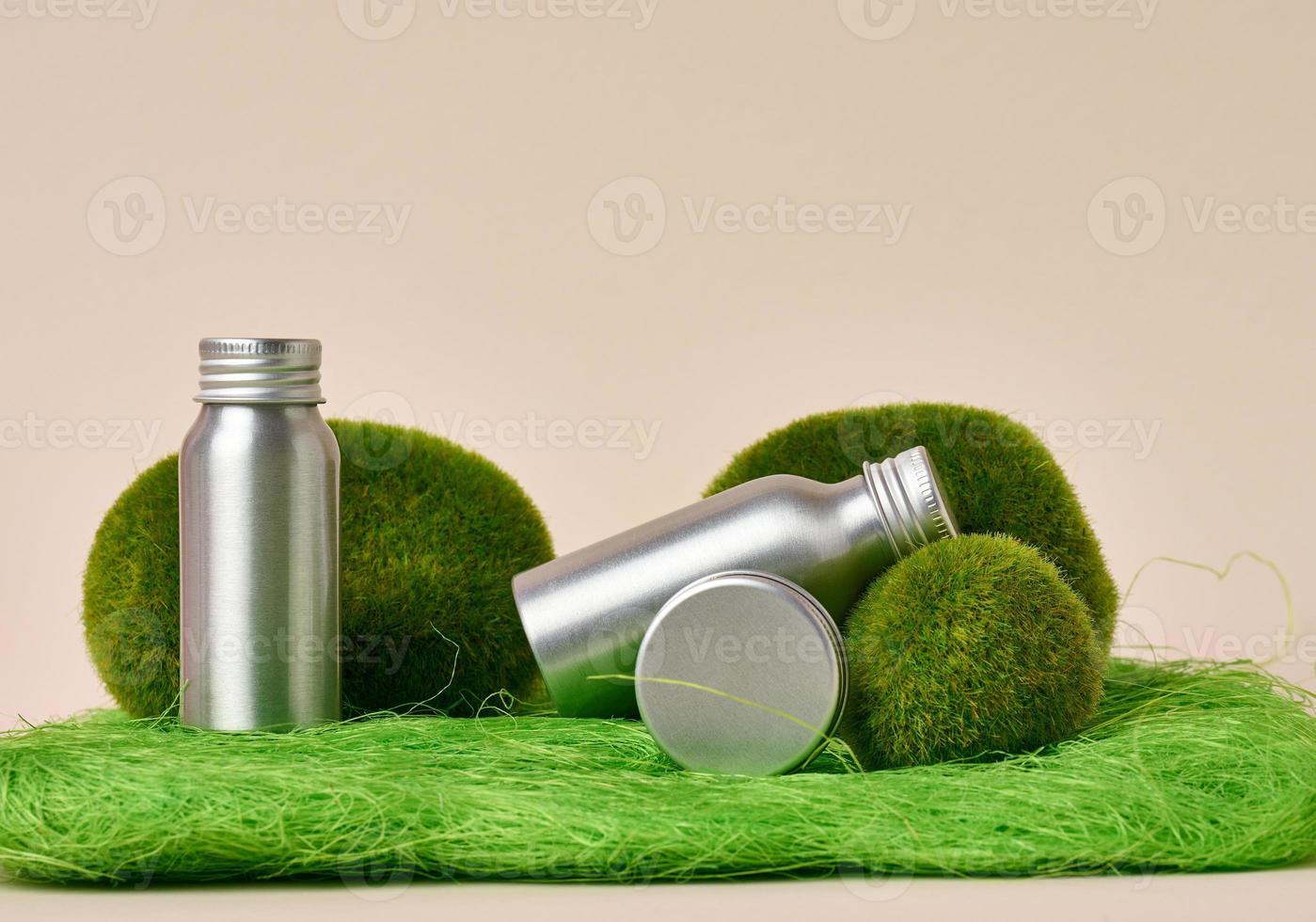 bocaux en métal gris, bouteille sur fond vert. emballage pour crème, gel, sérum, publicité et promotion de produits photo