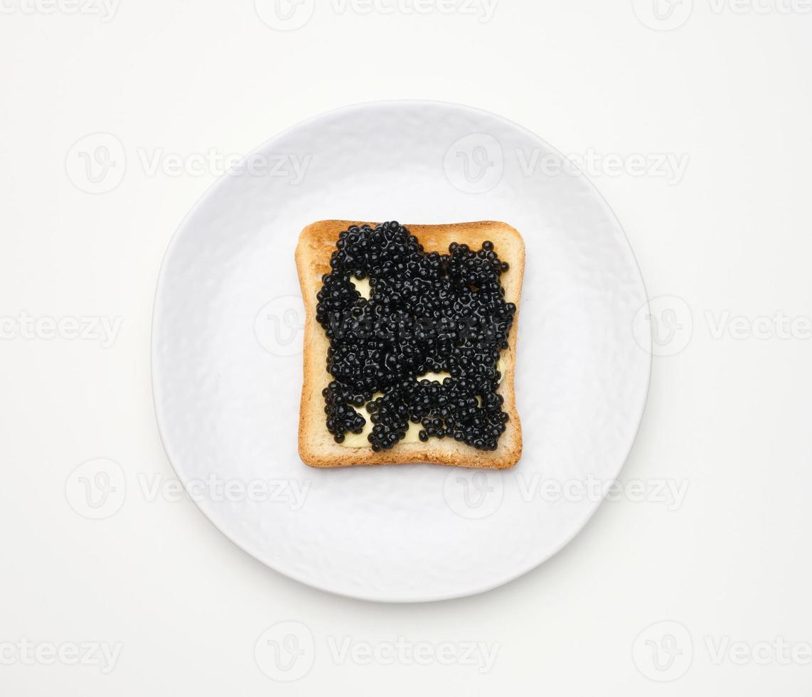 caviar de polyodons sur une tranche carrée de farine blanche de blé. vue de dessus sur tableau blanc photo