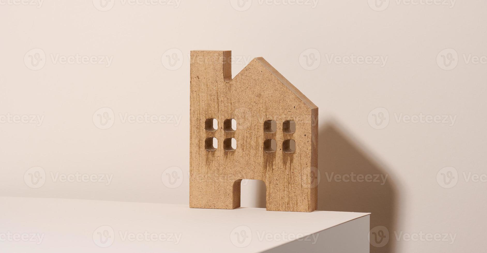 maison en bois marron sur fond beige. concept de location, d'achat et de vente de biens immobiliers. services d'agent immobilier, réparation et entretien de bâtiments photo