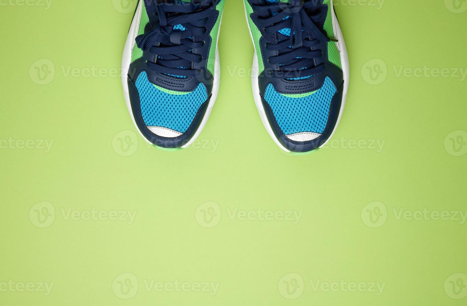 paire de baskets en textile bleu sur fond vert, vue de dessus. chaussures de sport photo