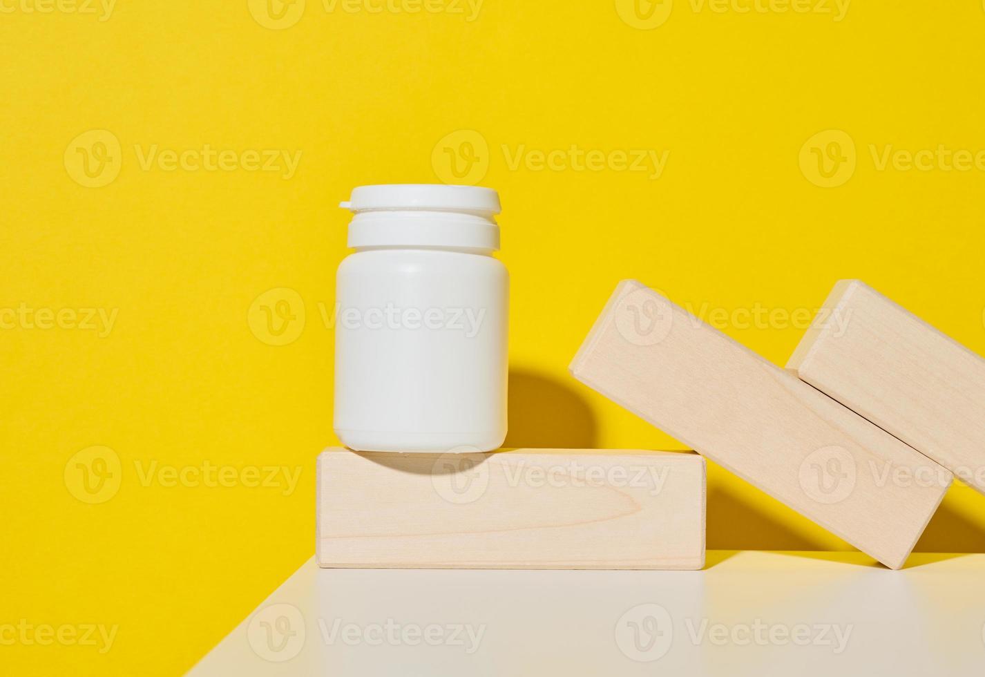 pot en plastique blanc pour pilules, crème et médicaments sur fond jaune. conteneur pour substances photo