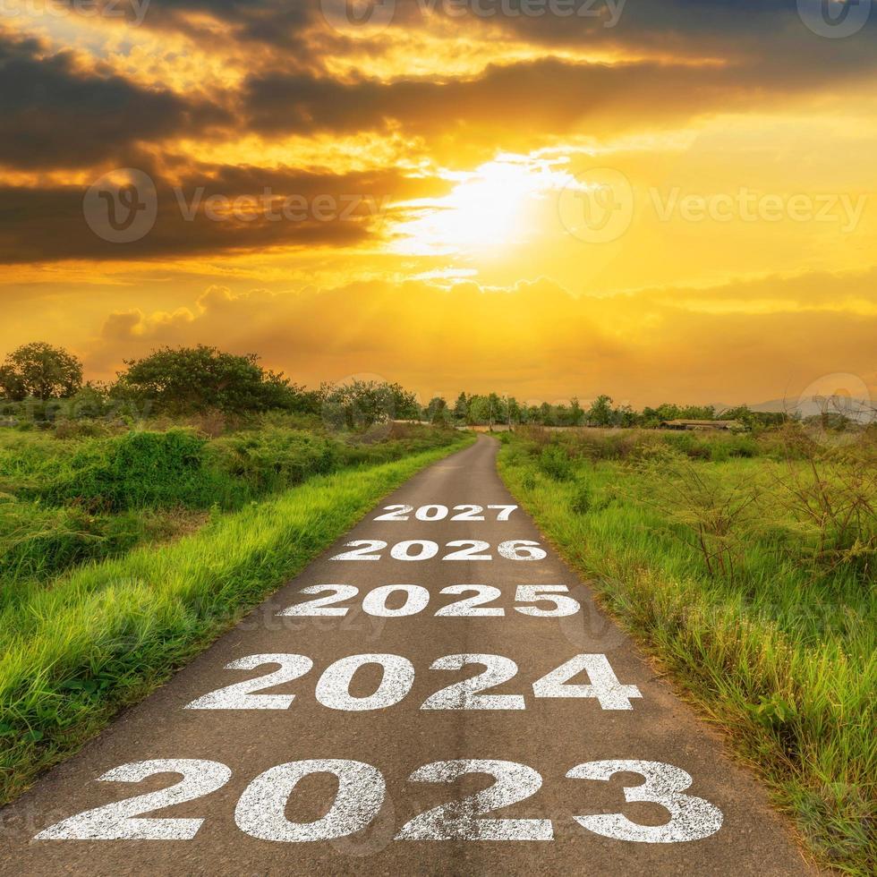 route asphaltée vide et concept du nouvel an 2023. conduire sur une route vide jusqu'en 2023 avec le coucher du soleil. photo