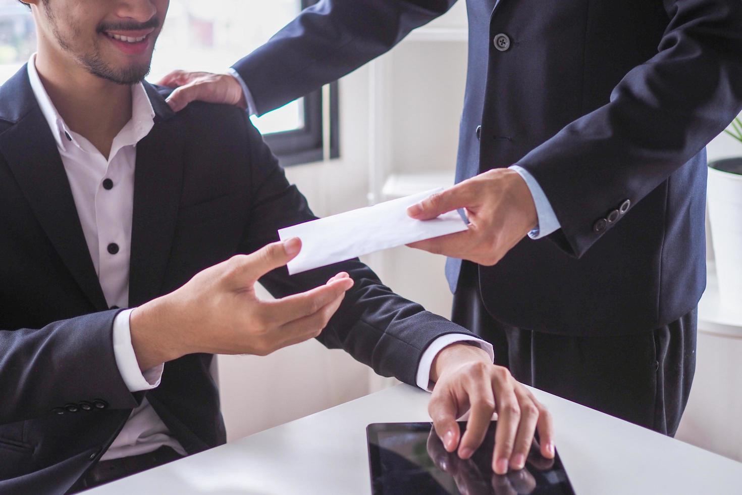 les managers acceptent des enveloppes de bonus du PDG après la synthèse des résultats annuels de l'entreprise. photo