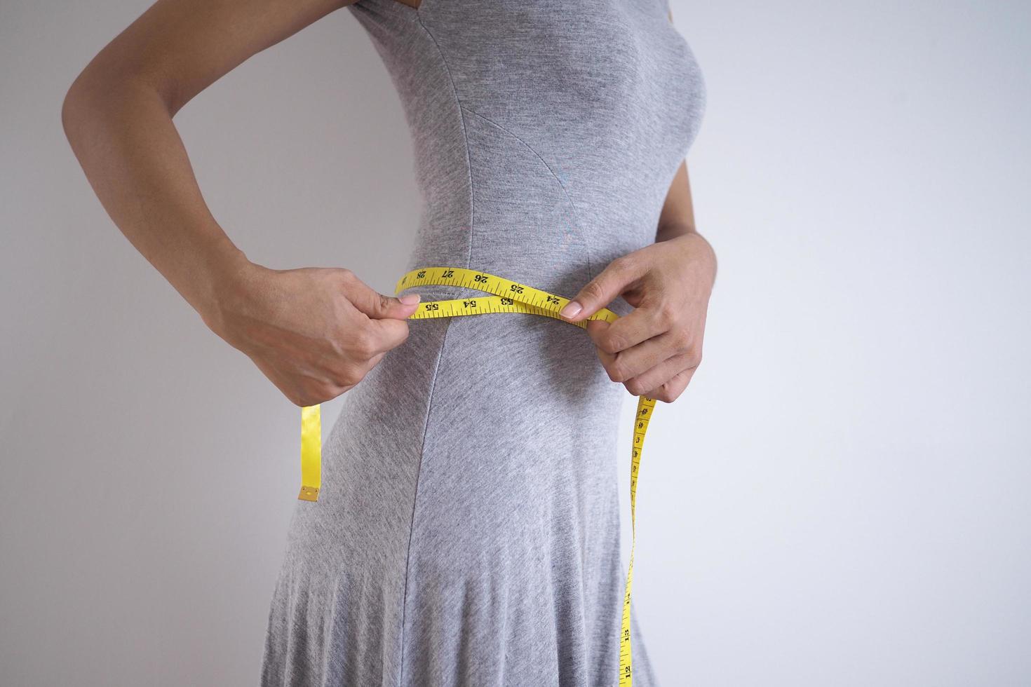 les filles mesurent la taille avec un ruban à mesurer après être entrées dans le programme de perte de poids. photo