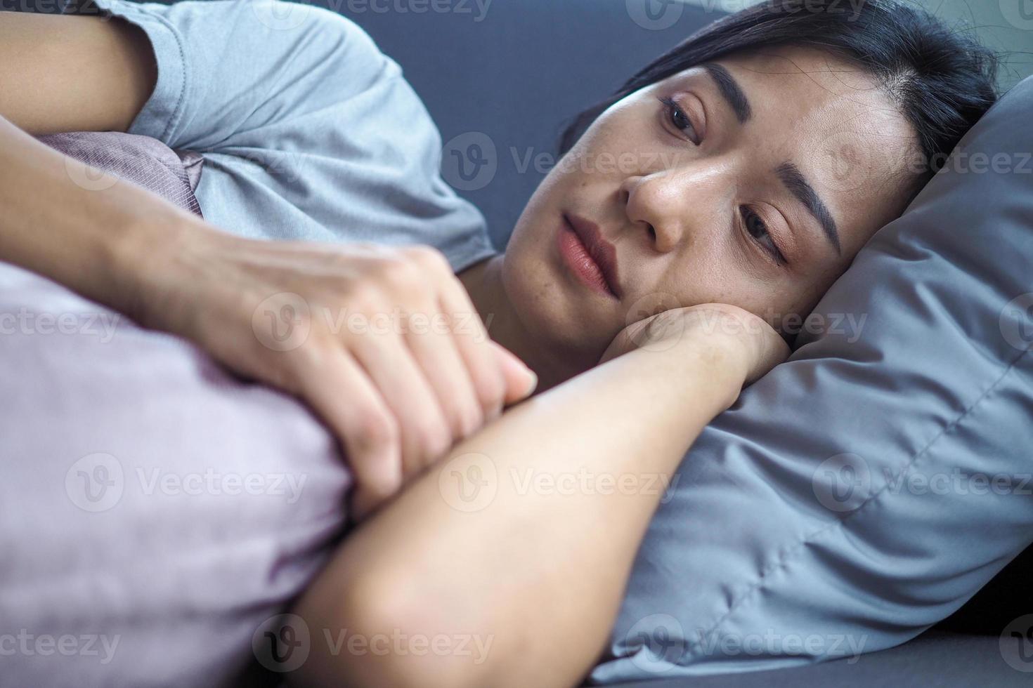 la fille a serré l'oreiller sur le canapé à l'intérieur de la maison, triste et distraite, se sent mal à propos des choses qui se sont produites. photo