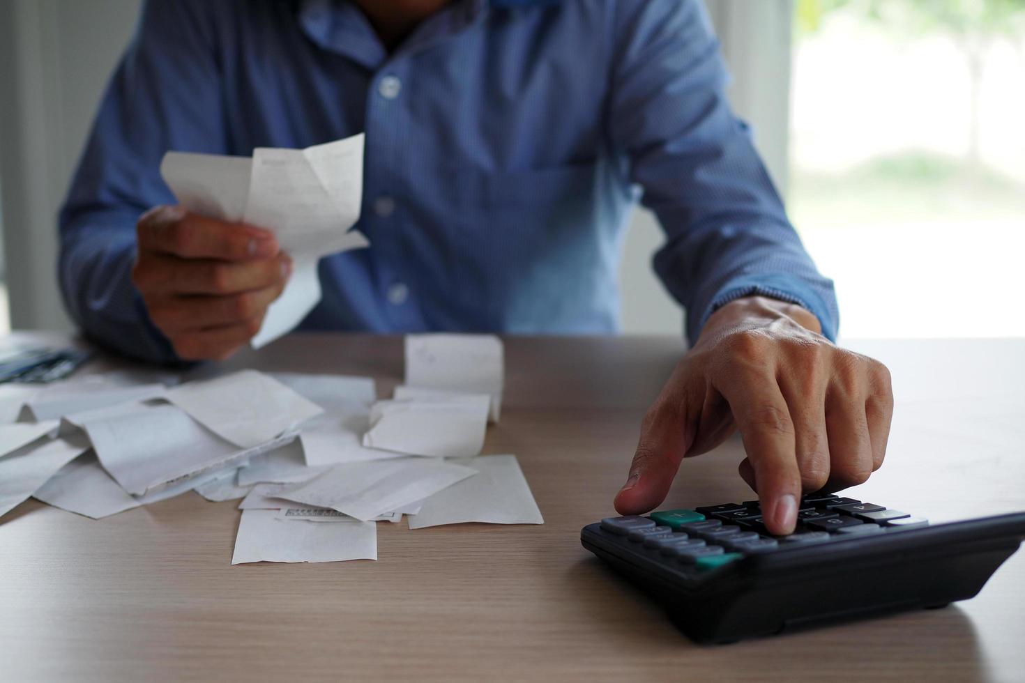 les hommes d'affaires utilisent la calculatrice pour calculer la facture placée sur la table. notion de dette photo