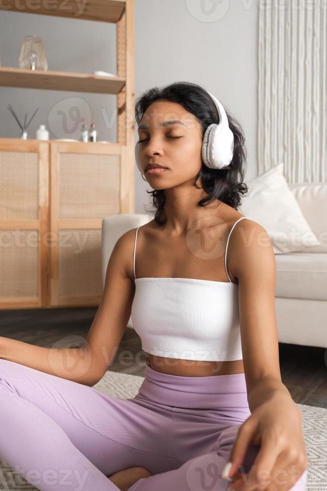 bannière verticale avec portrait de vue latérale sur une femme noire sereine dans des écouteurs méditant, écoutant de la musique relaxante photo