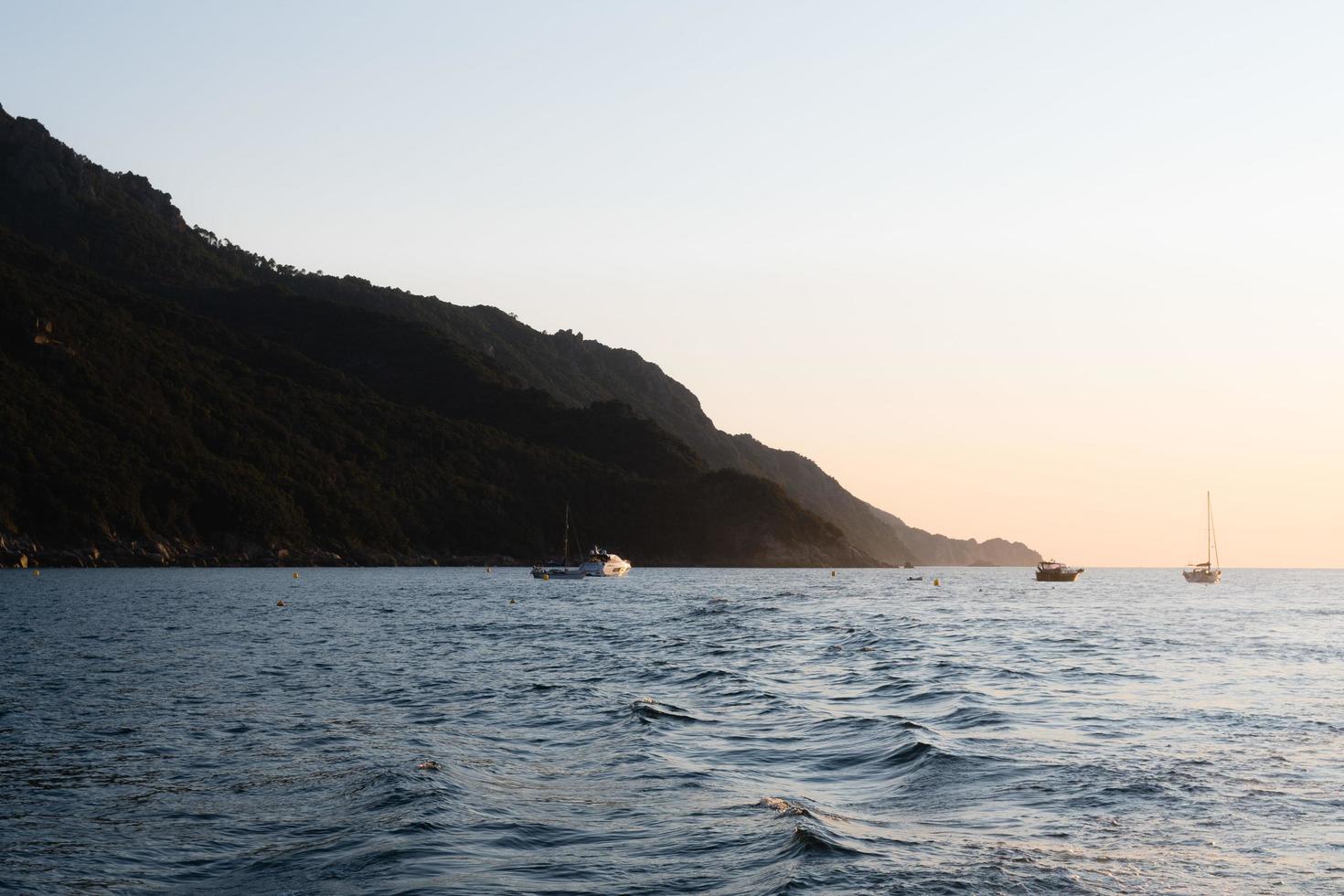 bateaux dans la mer au coucher du soleil photo