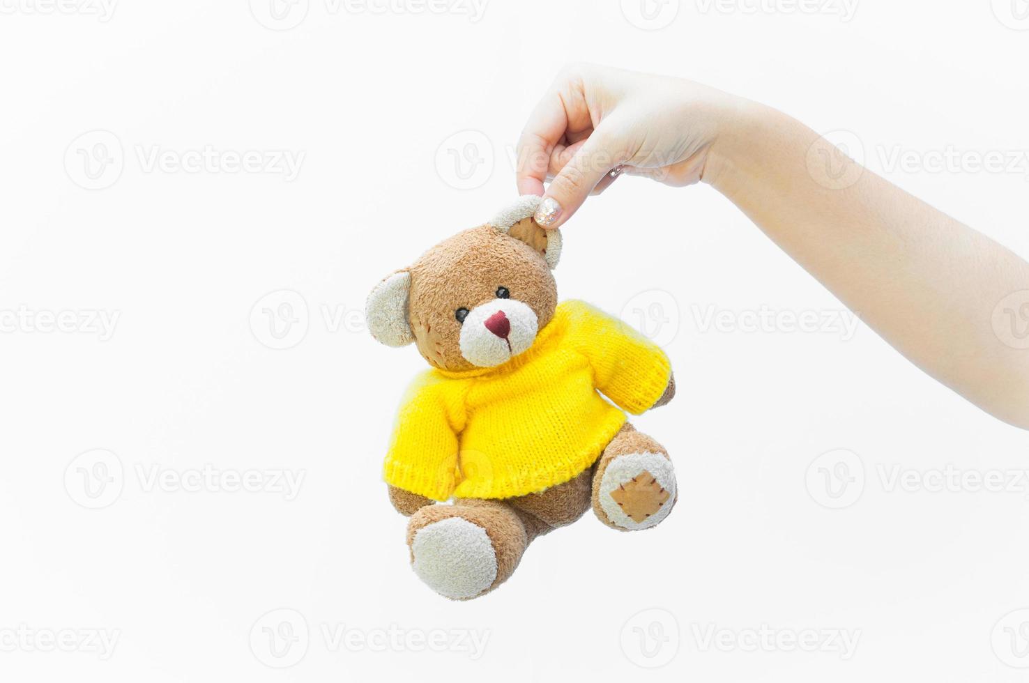 Woman holding ours en peluche brun oreille toy porter des chemises jaunes sur fond blanc photo