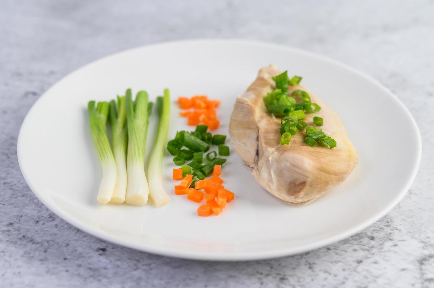 poitrine de poulet cuite à la vapeur avec oignons nouveaux et carottes hachées photo