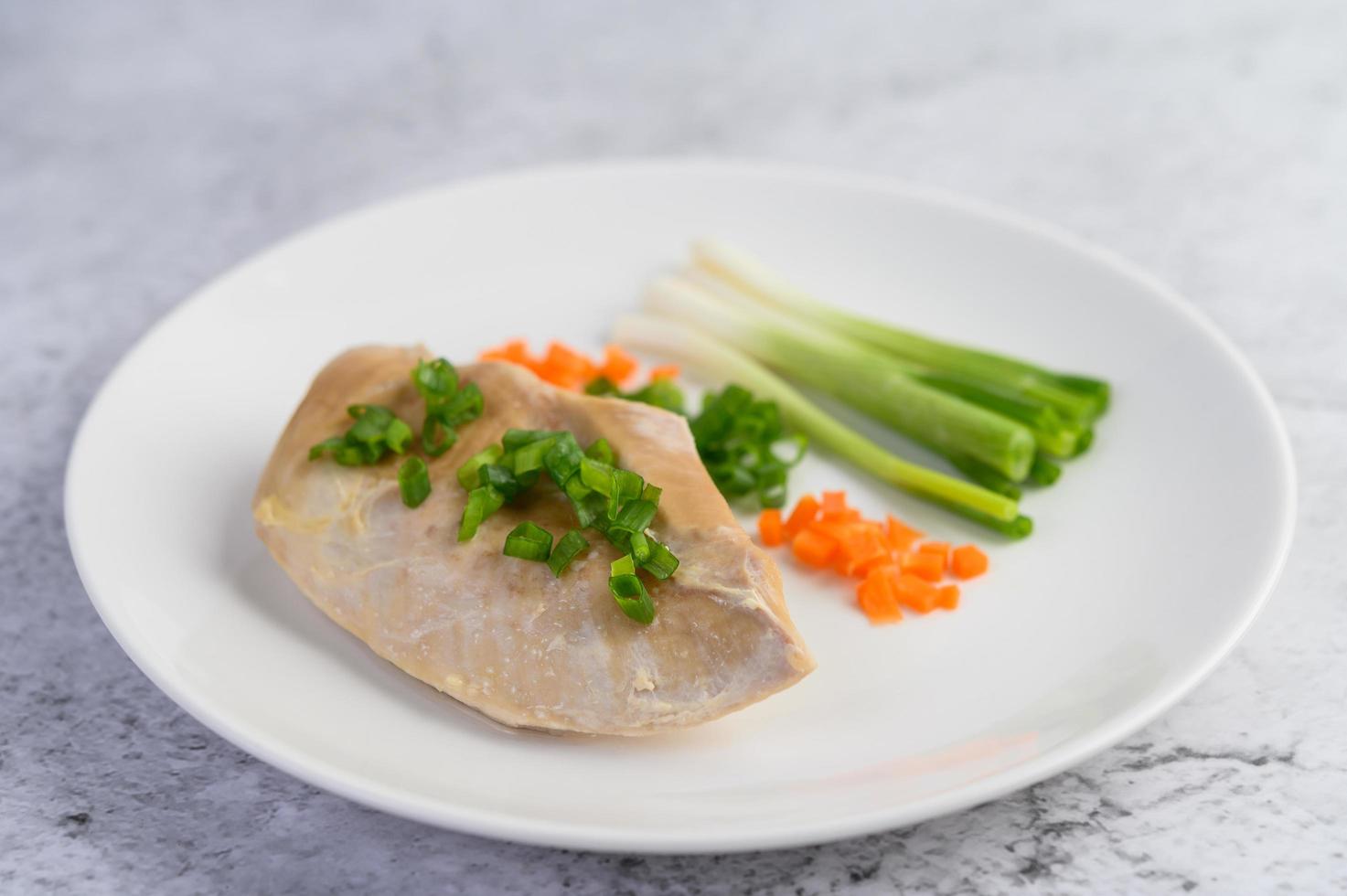 poitrine de poulet cuite à la vapeur avec oignons nouveaux et carottes hachées photo