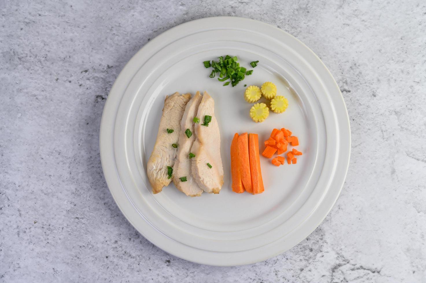 poitrine de poulet cuite à la vapeur avec oignons nouveaux et carottes hachées photo