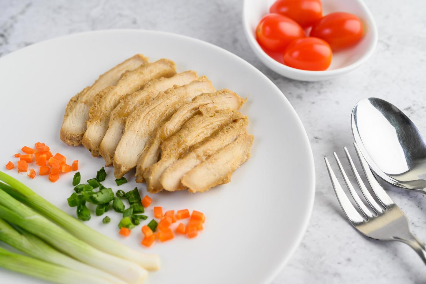 poitrine de poulet cuite à la vapeur avec oignons nouveaux et carottes hachées photo