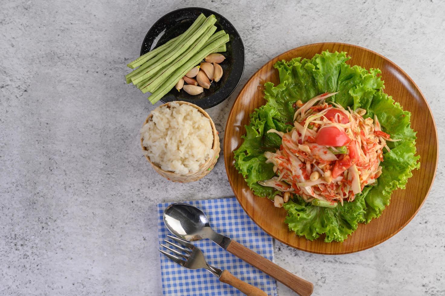 salade de papaye thaï avec riz gluant, cuillère et fourchette photo