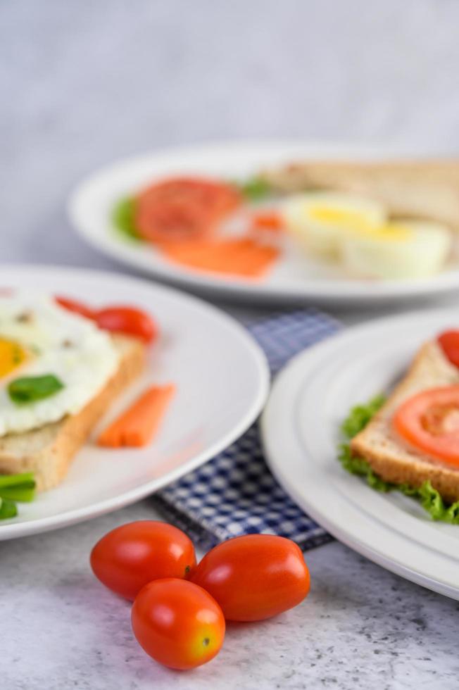 un œuf frit avec du pain grillé, des carottes, du maïs et des oignons nouveaux photo