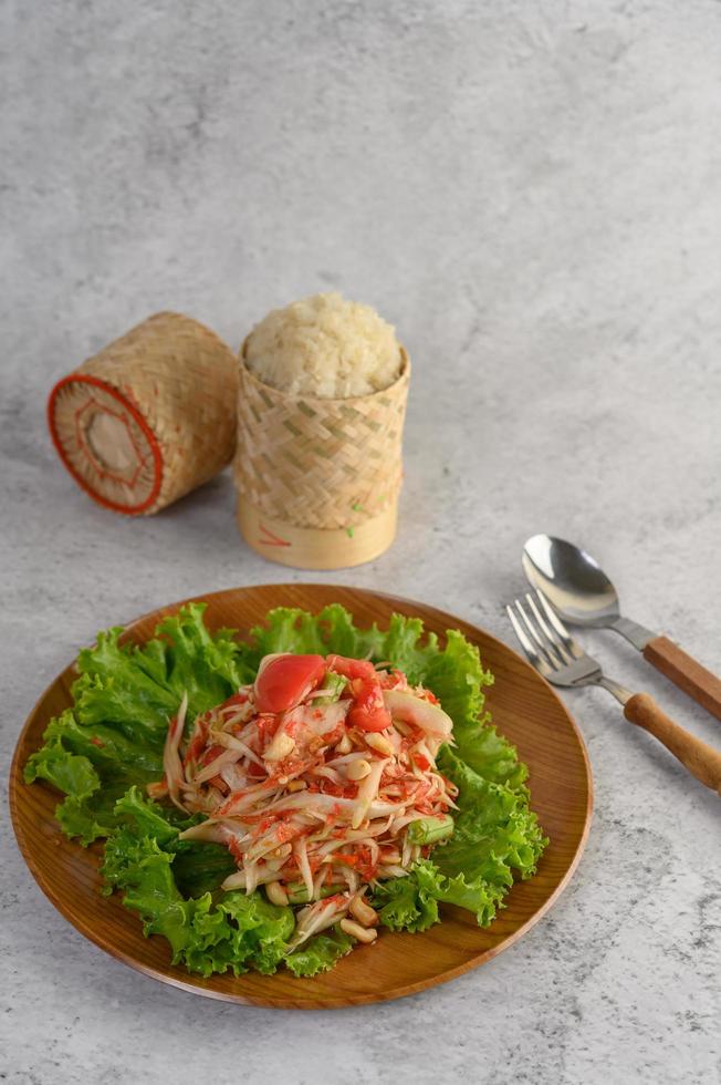 salade de papaye thaï avec riz gluant, cuillère et fourchette photo