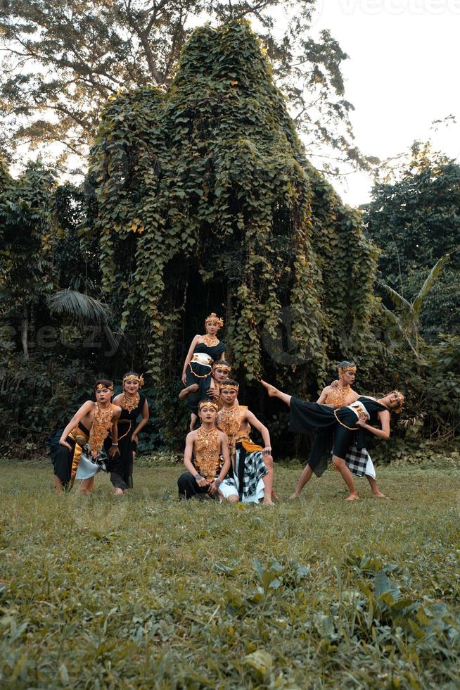 des danseurs indonésiens posent avec leur corps tout en portant un costume doré traditionnel de javanais photo