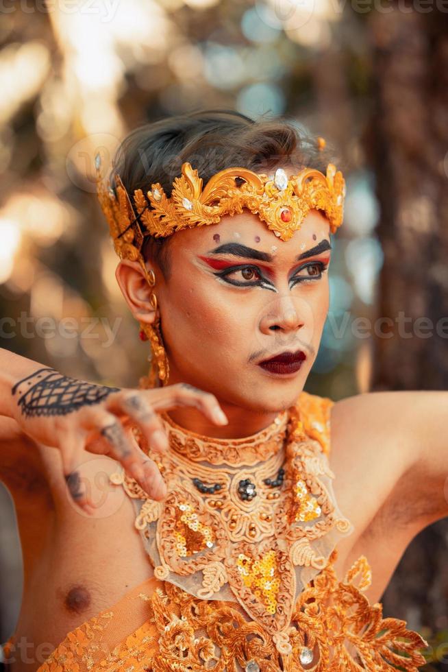 visage balinais maquillé et portant une couronne dorée et un collier doré avant le début du spectacle de danse photo