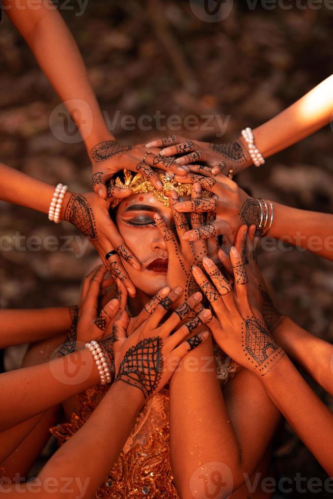 visages d'homme triste couverts par beaucoup de mains avec des tatouages au henné tout en portant une couronne d'or photo