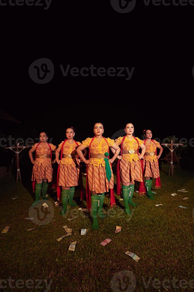 danseurs balinais debout avec une écharpe rouge et des costumes orange sur la scène après avoir exécuté la danse traditionnelle photo