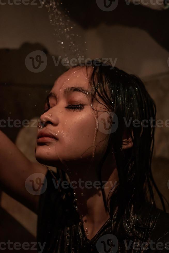 les femmes anxieuses passent une journée triste pendant qu'elle se douche le visage avec de l'eau photo