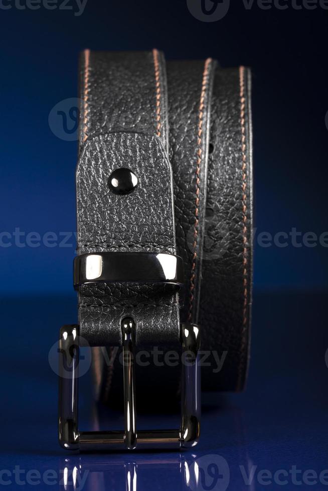 ceinture en cuir noir sur fond bleu foncé. photo