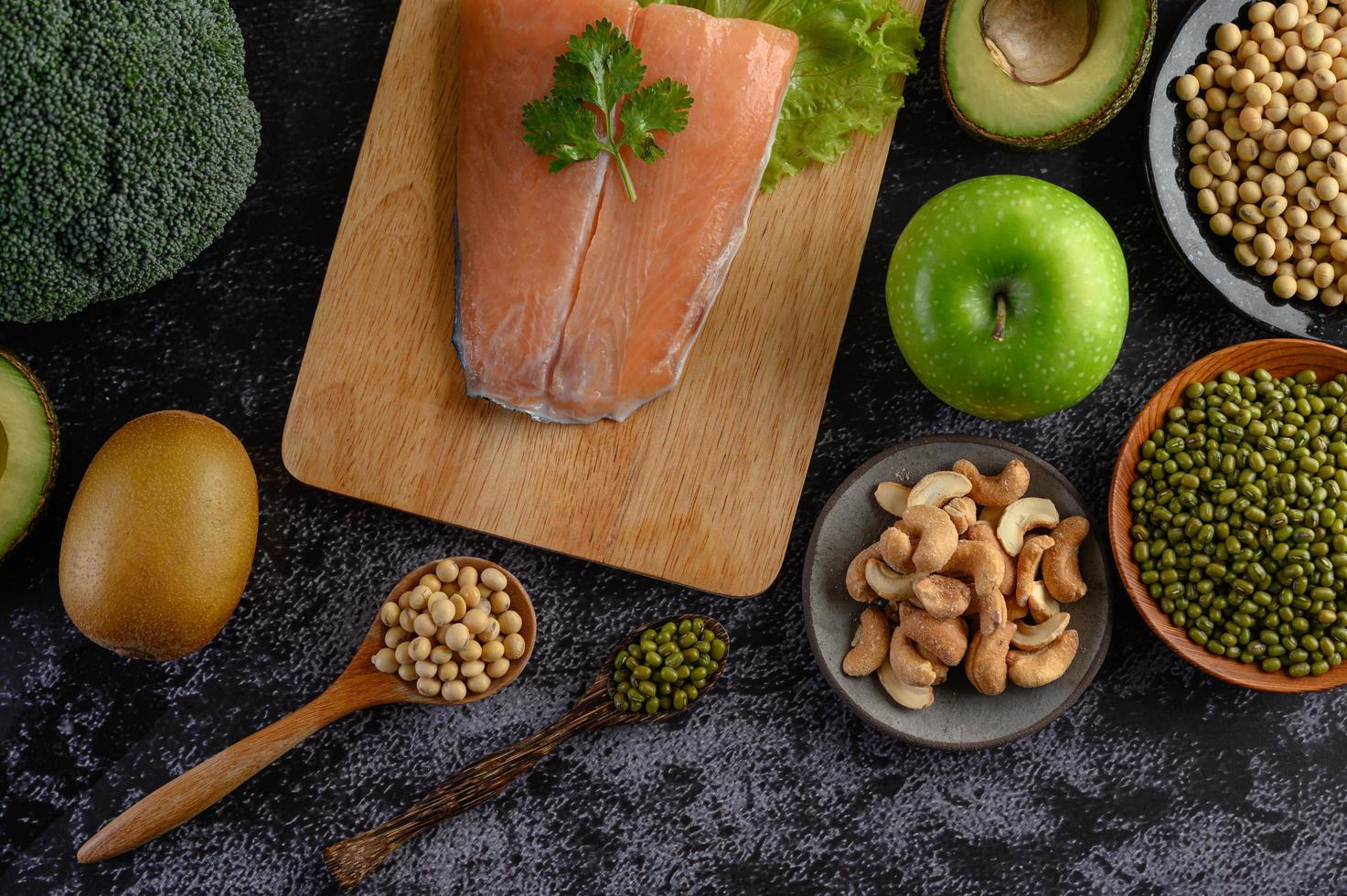 Légumineuses, fruits et saumon sur une planche à découper en bois photo