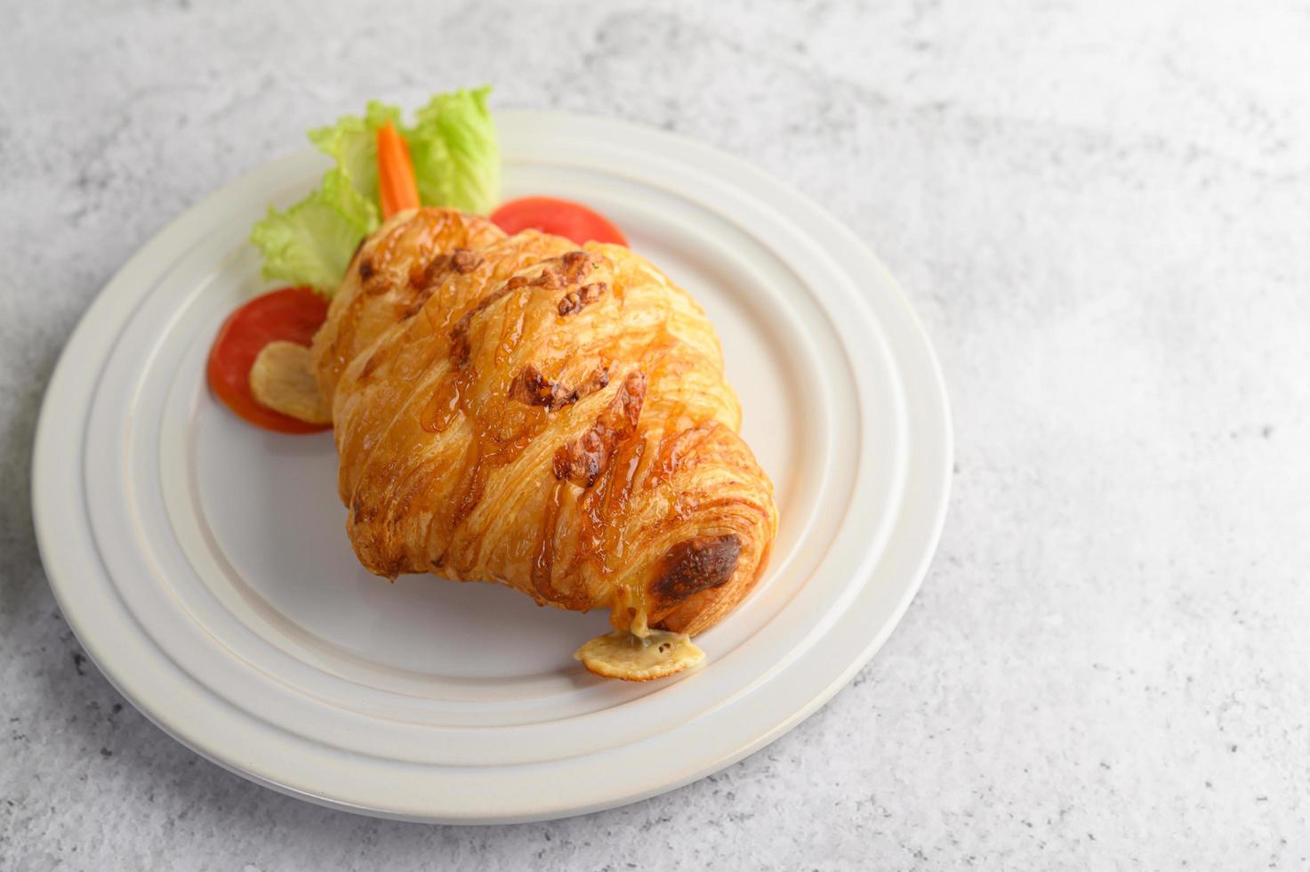 un croissant avec hot-dog sur plat blanc photo