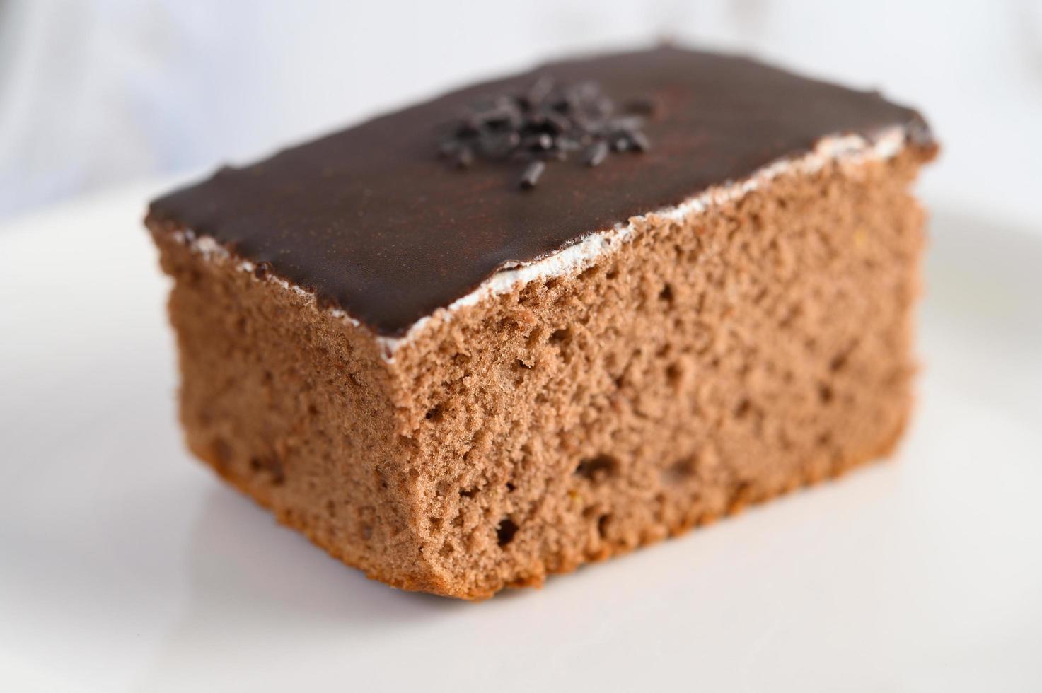 Gâteau au chocolat sur une plaque blanche et table en bois blanc photo