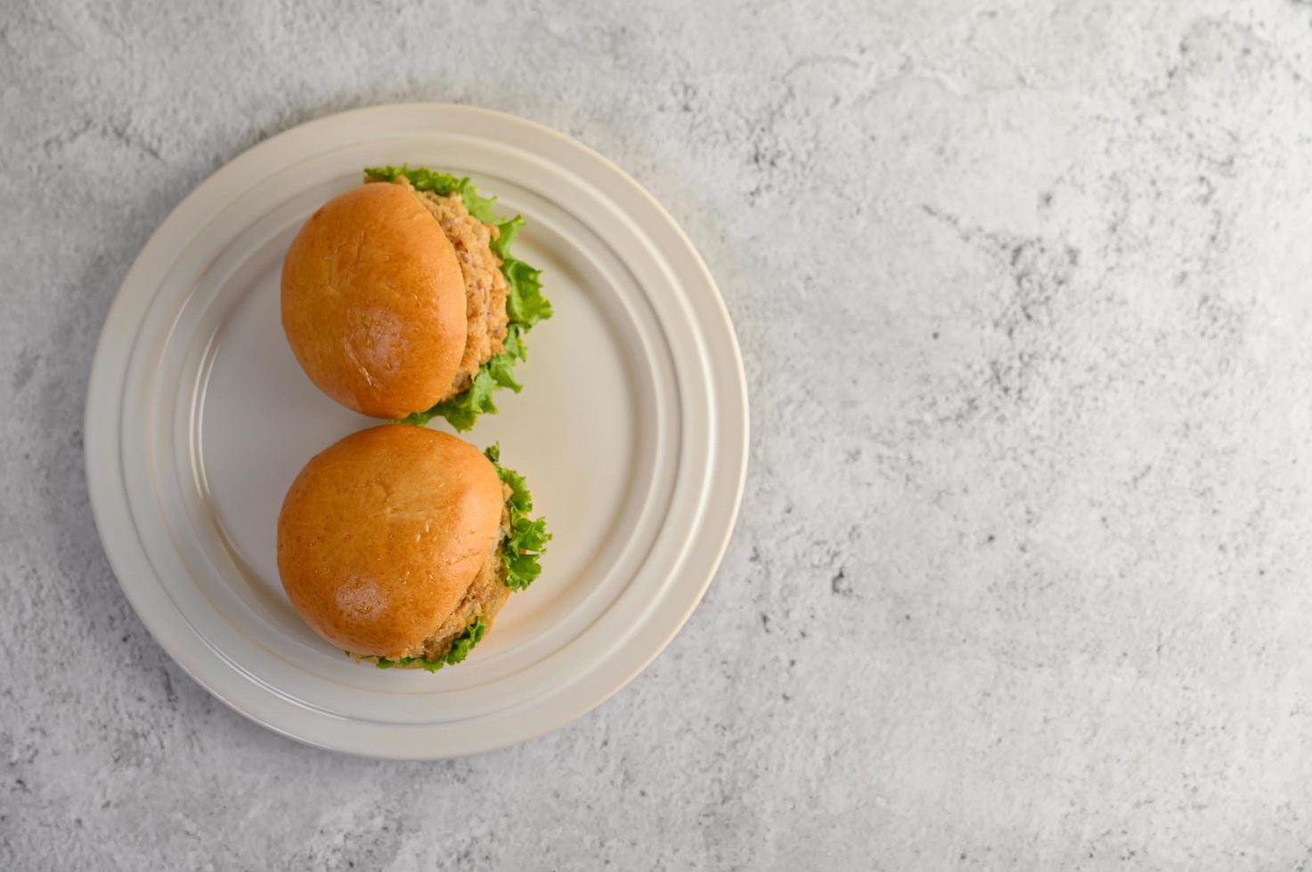 deux hamburgers placés sur un plat blanc magnifiquement photo