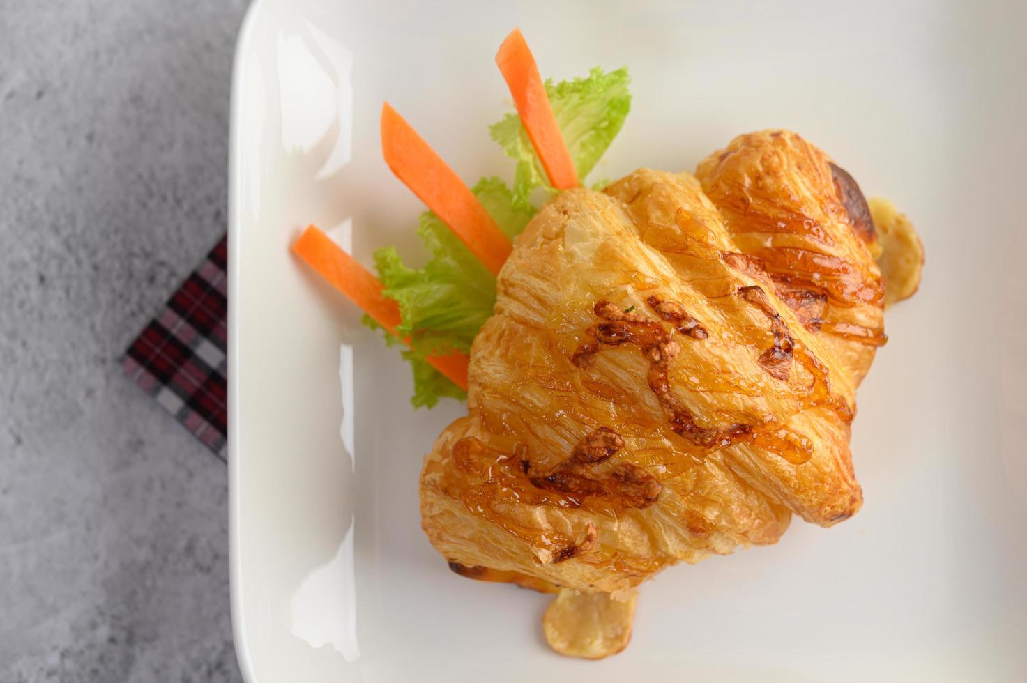 un croissant avec hot-dog sur plat blanc photo