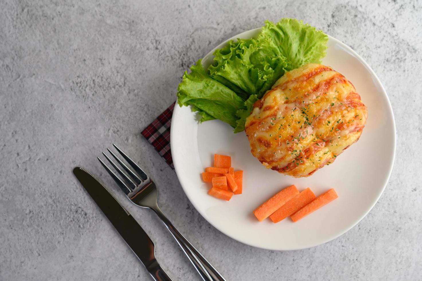 Un rouleau de pain aux saucisses sur un plat blanc photo