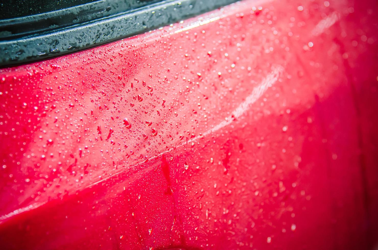 gouttes deau sur une voiture rouge photo