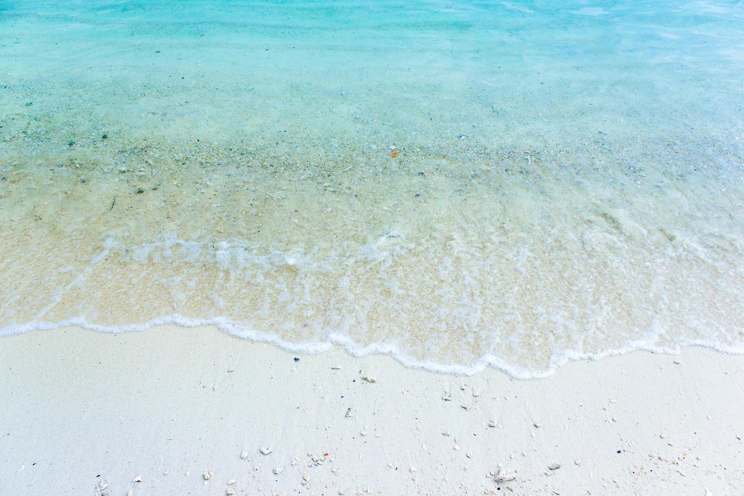 sable blanc avec de l'eau bleue photo