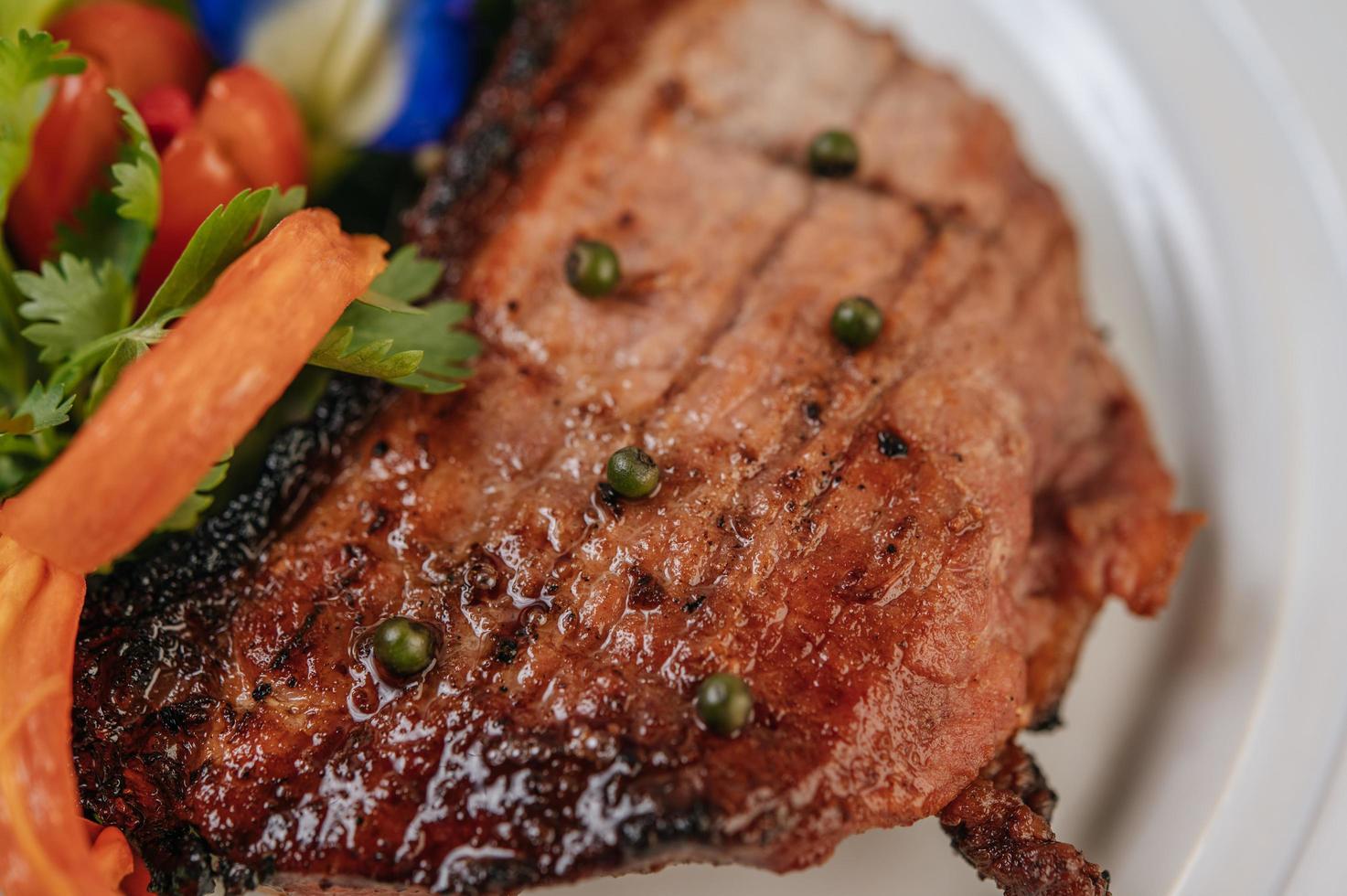 steak de porc à la tomate, carotte, oignon rouge, menthe poivrée, fleur de pois papillon et citron vert photo