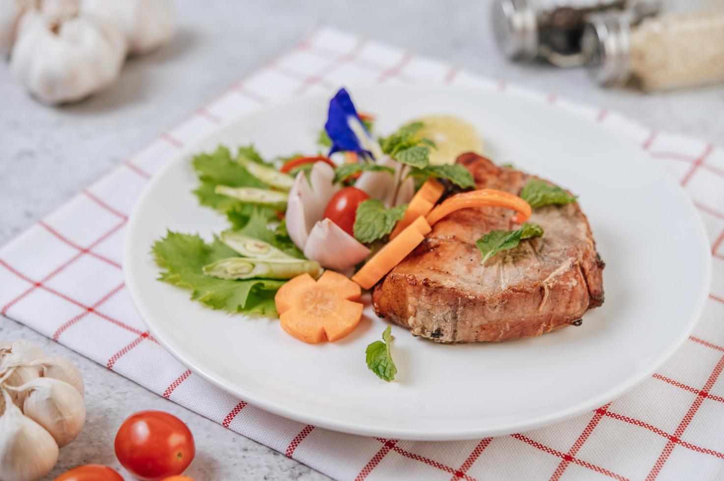 steak de porc à la tomate, carotte, oignon rouge, menthe poivrée, fleur de pois papillon et citron vert photo