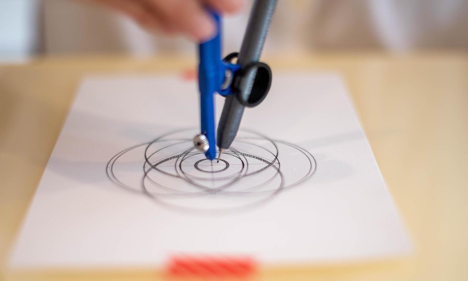 main féminine à l'aide d'un cercle de mesure se préparant à dessiner et à esquisser le concept de mandala sur le papier blanc vide. photo