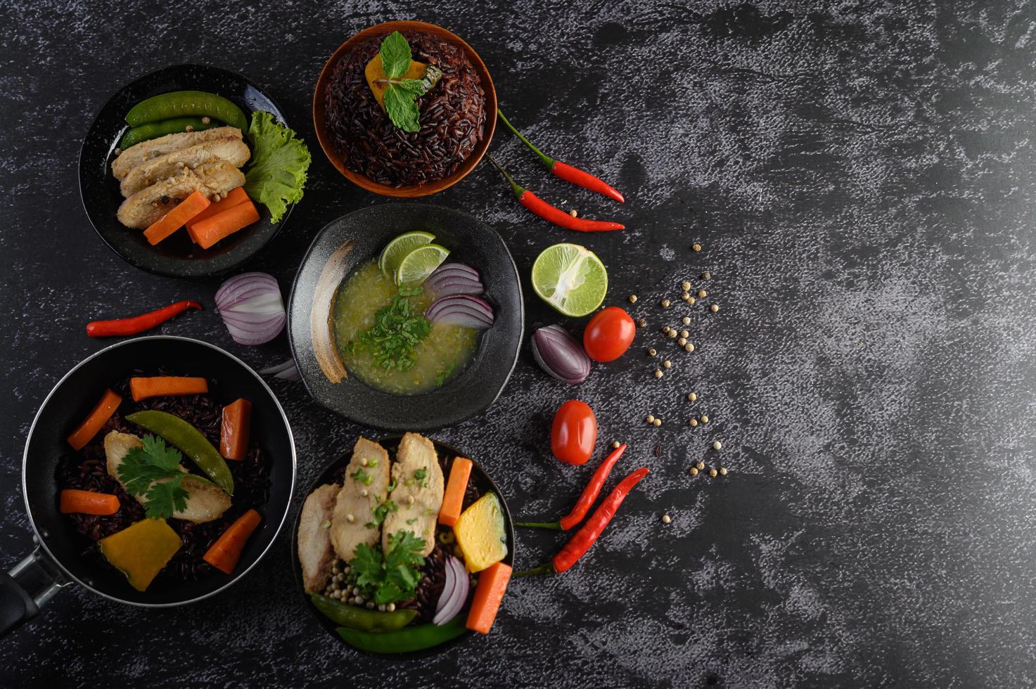 Assortiment de plats de légumes, de viande et de poisson sur un fond de pierre noire photo
