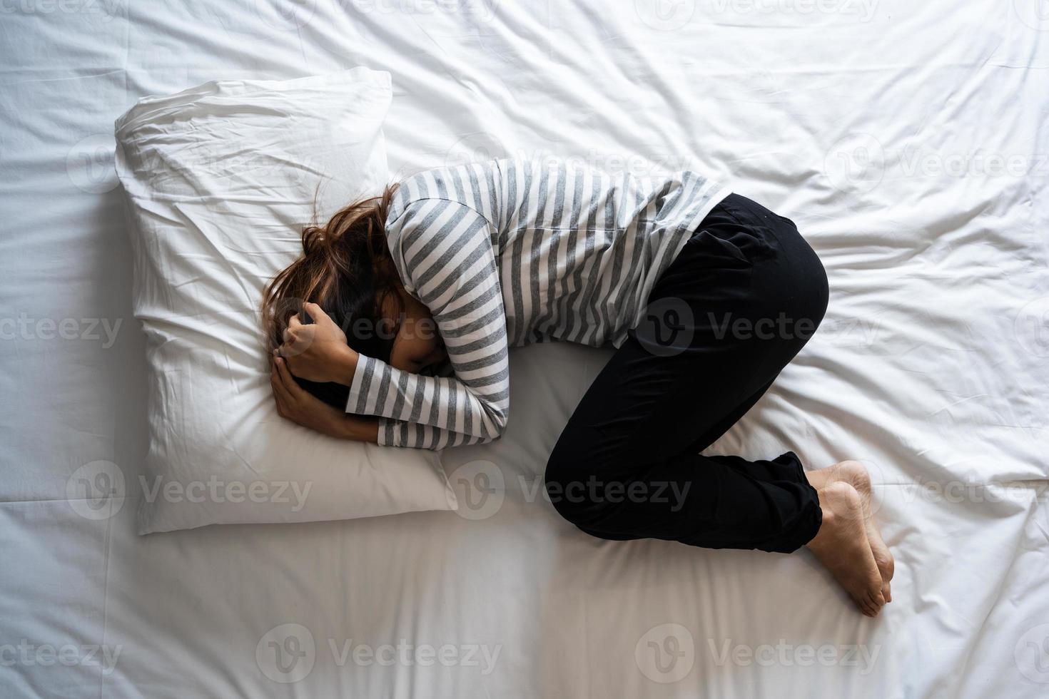 jeune femme solitaire déprimée et stressée sur le lit, émotion négative et concept de santé mentale photo